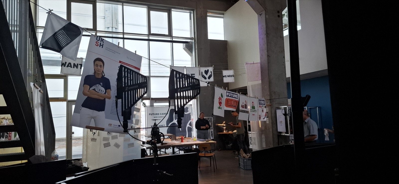 CARE LAB worktable and suspended printed materials in the exhibition space