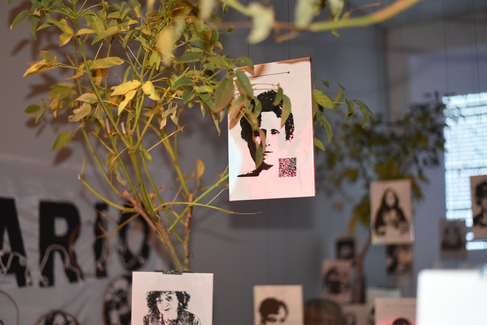 Close view of a portrait with QR code suspended from a living plant