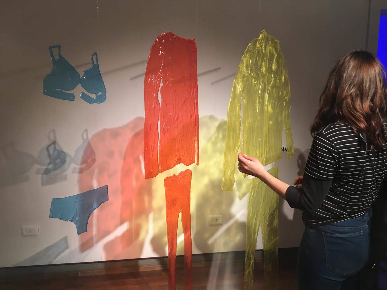 Visitor encountering the translucent garment installation in the exhibition